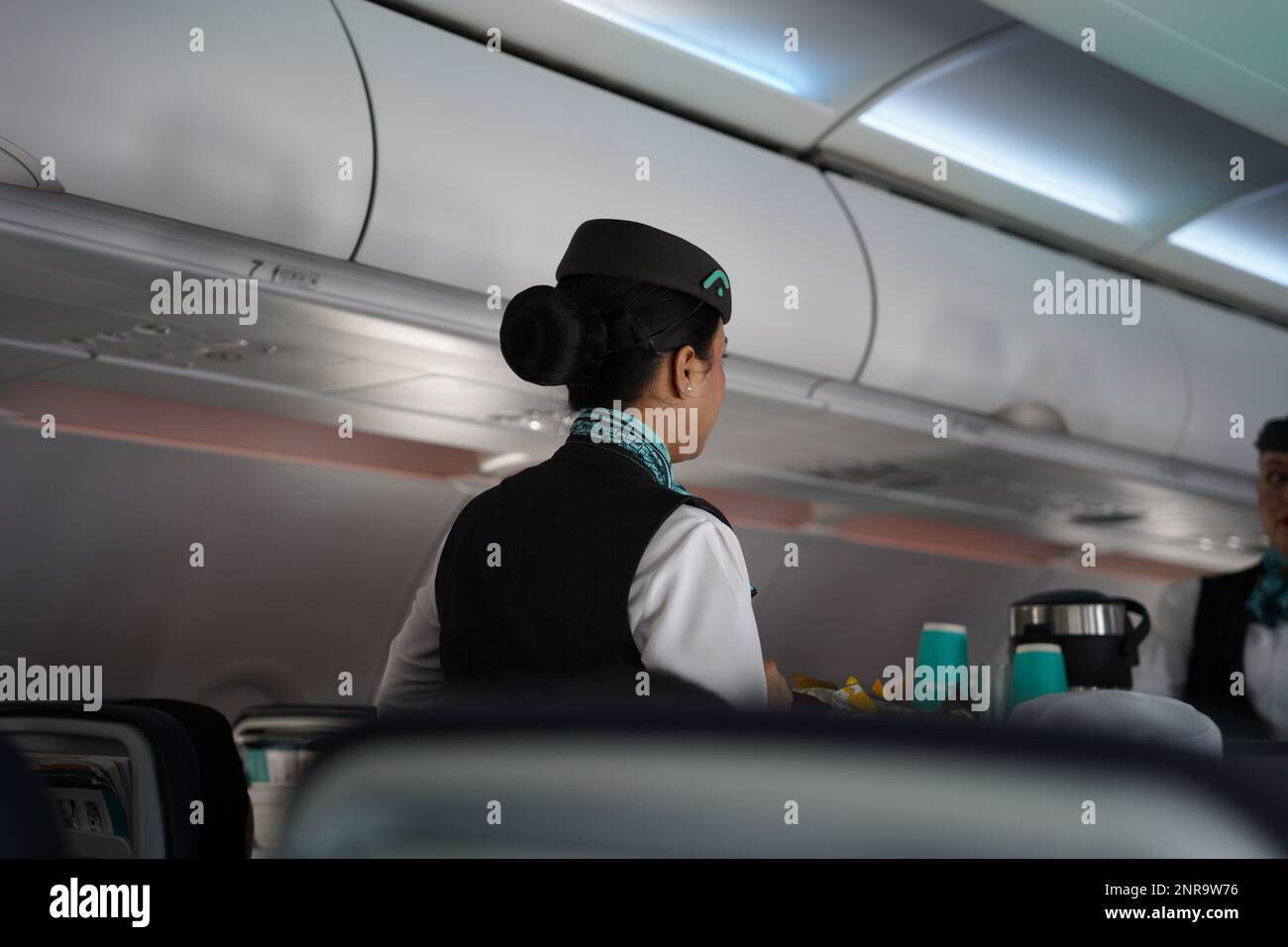 Flynass Flugbegleiterin oder Crew, eine Frau, die im Flugzeug arbeitet und Essen und Getränke serviert, traditionell bekannt als Flugbegleiterin, Stewardess, Steward, o Stockfoto