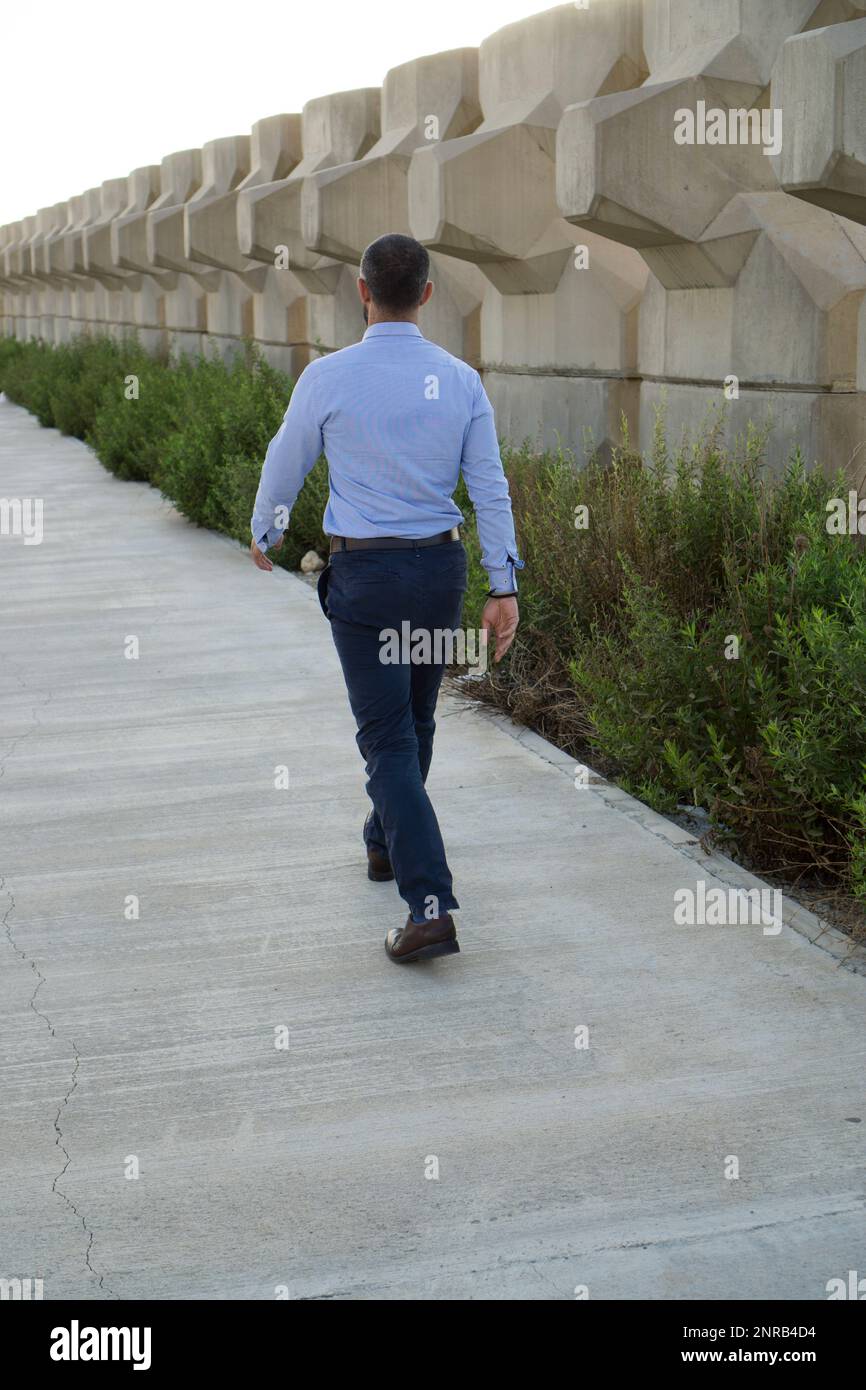 Rückansicht eines Mannes, der draußen weggeht Stockfoto