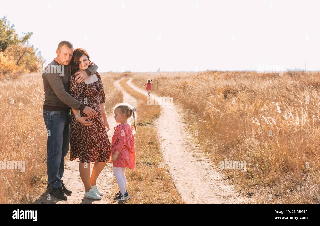 Familie mit Drillingen auf einem Spaziergang. Glückliche Eltern Stockfoto