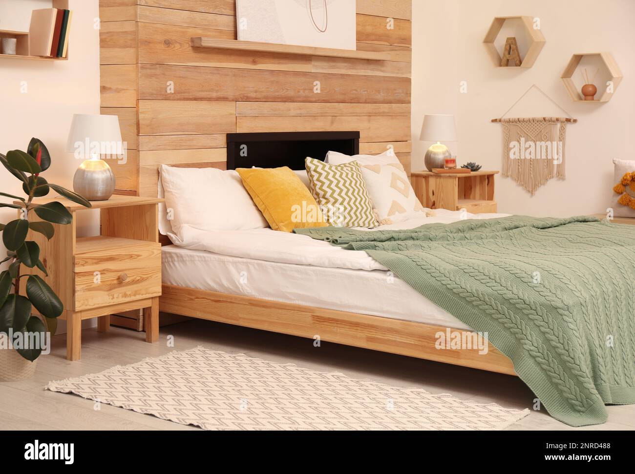 Stilvolle Innenausstattung mit großem, komfortablem Bett Stockfoto
