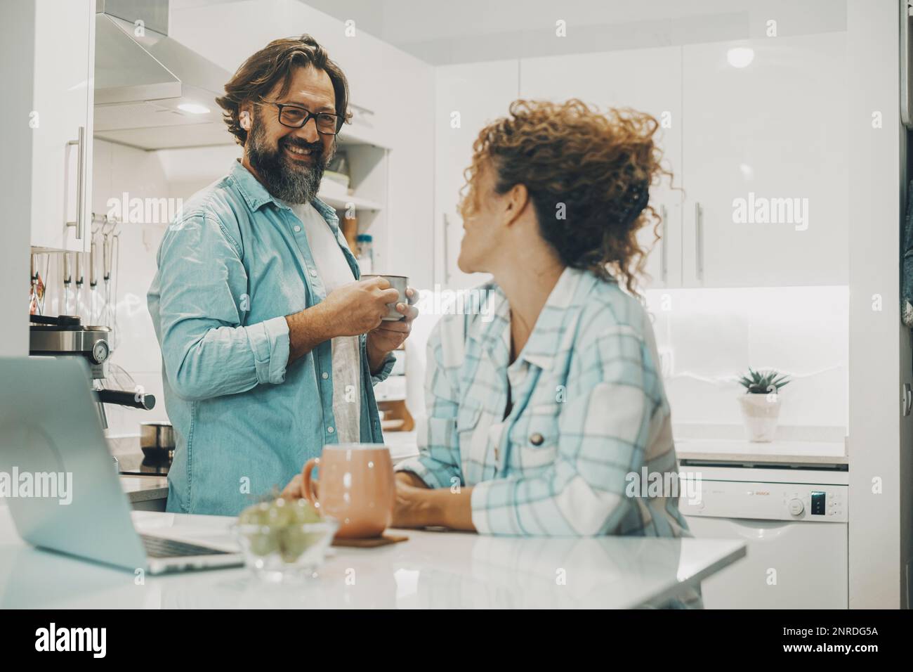 Ein echtes Paar zu Hause lächelt und genießt Liebe und Beziehung beim gemeinsamen Frühstück. Weißes Ambiente-Haus mit Innenausstattung. Mann und Frau Leute am Morgen Stockfoto