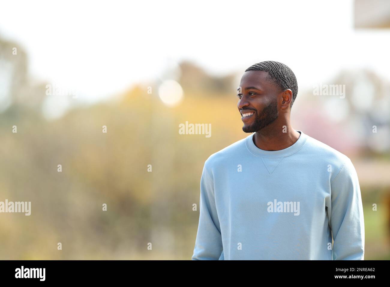 Ein glücklicher Schwarzer, der in einem Park auf Side blickt Stockfoto