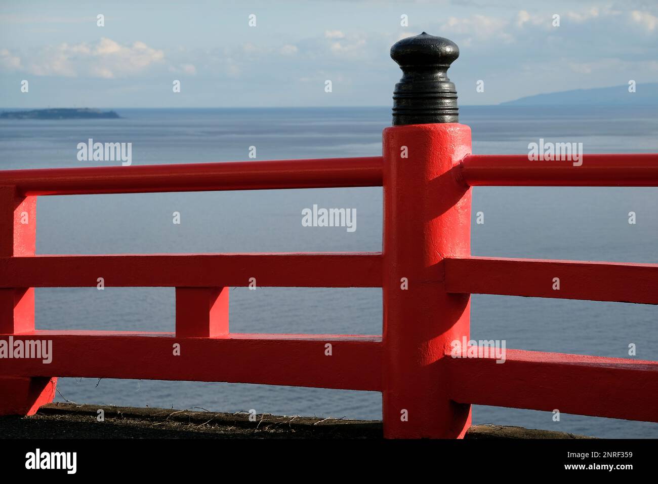Roter Zaun nahe der Küste mit Meer im Hintergrund in Enoshima, Japan Stockfoto