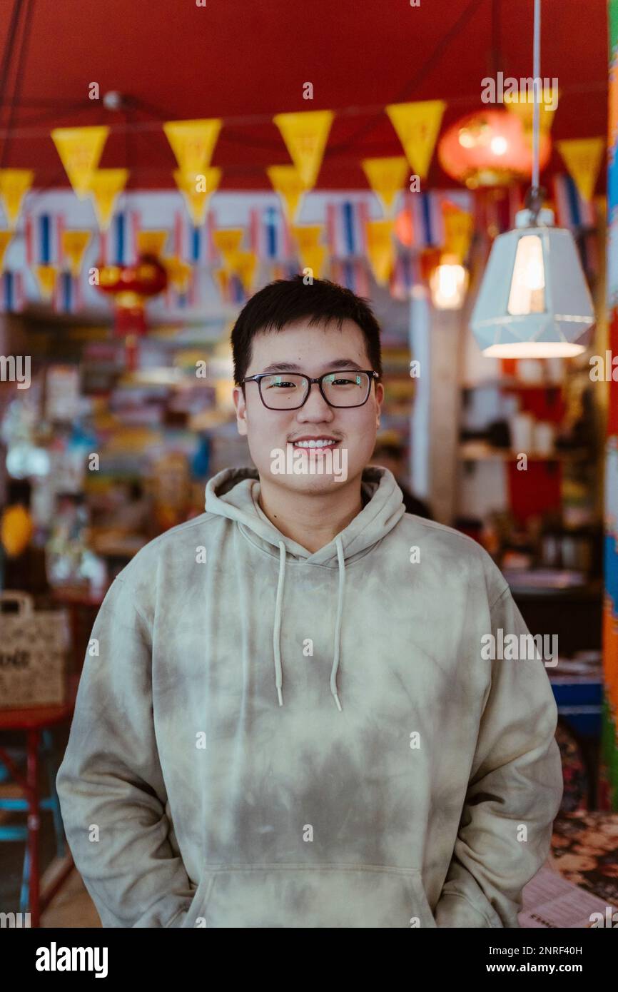 Porträt eines lächelnden jungen Mannes mit Kapuze im Restaurant Stockfoto