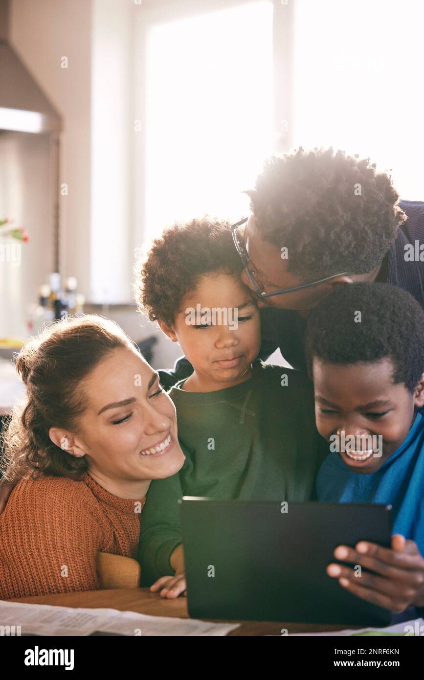 Eine Multirassenfamilie, die sich zu Hause ein digitales Tablet ansieht Stockfoto