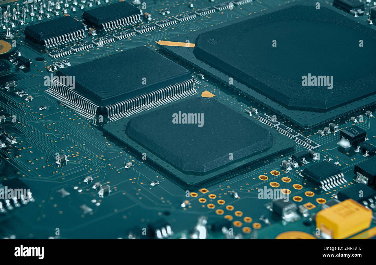 Nahaufnahme der Leiterplatte mit Prozessor, integrierten Schaltungen und vielen anderen auf der Oberfläche montierten passiven elektrischen Komponenten. Stockfoto