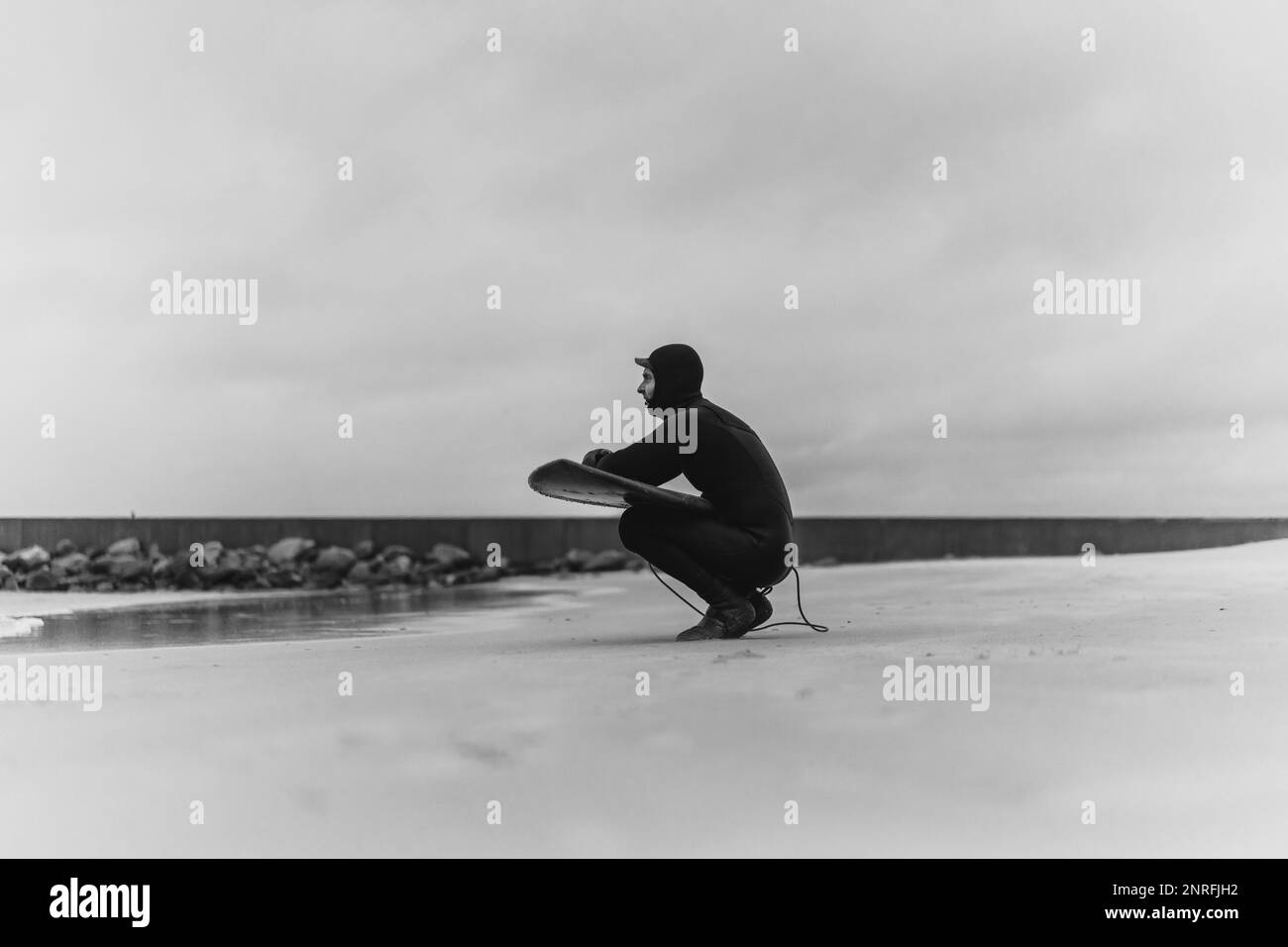 Surfen in Kamtschatka. Ein Mann in einem Neoprenanzug mit einem Surfbrett auf den s Stockfoto