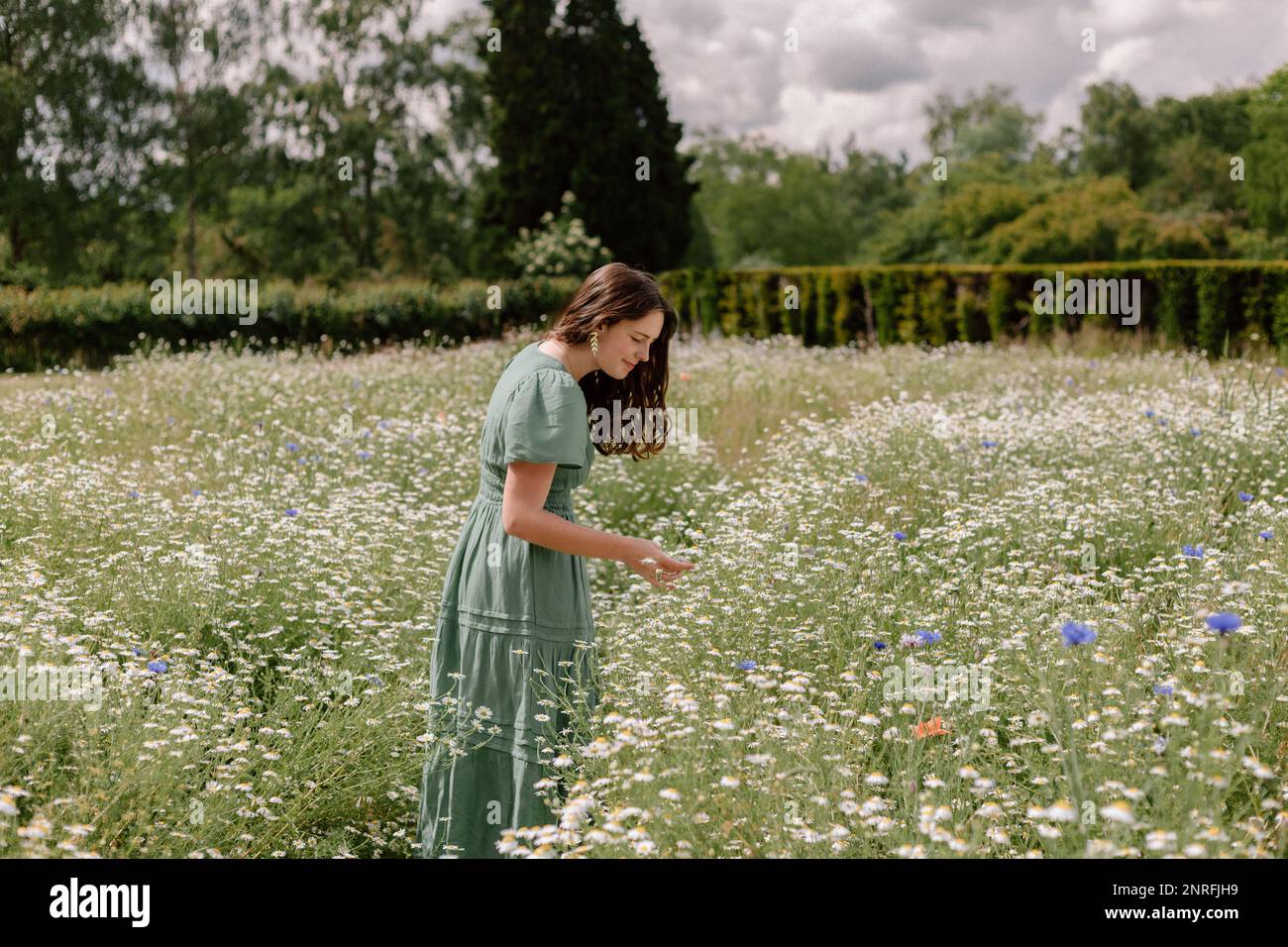 Eine Frau in grünem Kleid auf einem wilden Blumenfeld Stockfoto