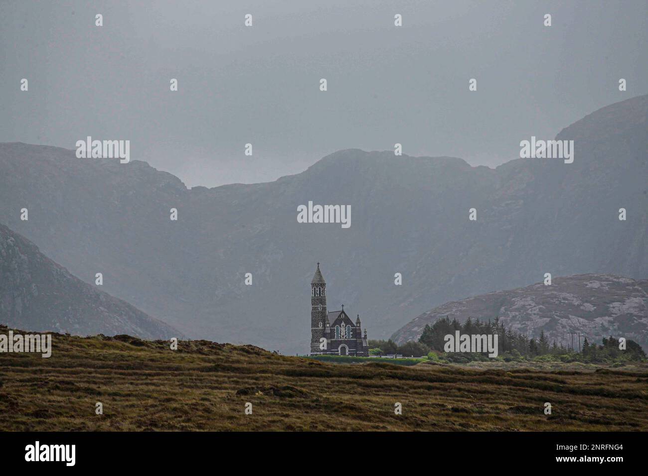 Kirche inmitten hoher Hügel in Irland Stockfoto