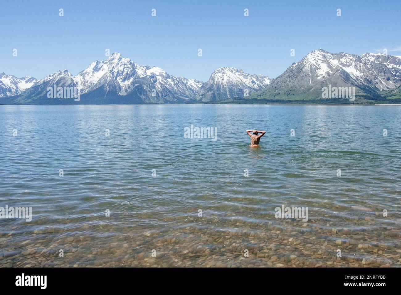 Ein Teenager, der allein im Bergsee schwimmt Stockfoto