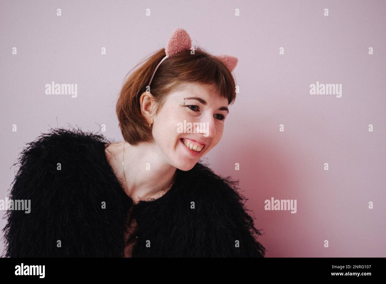 Frau mit rosa Ohren auf rosa Hintergrund Stockfoto