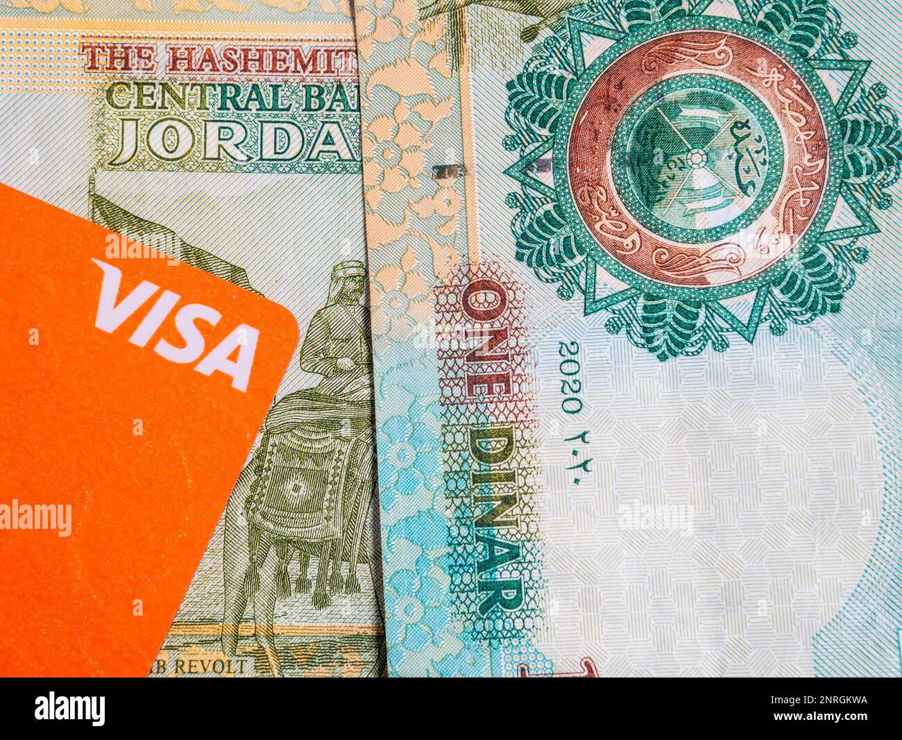 Bukarest, Rumänien - 02.22.2023: Makrodetailbild mit jordanischen Dinar-Banknoten und einer Visa-Kredit- oder Debitkarte. JOD ist die offizielle Währung in Stockfoto