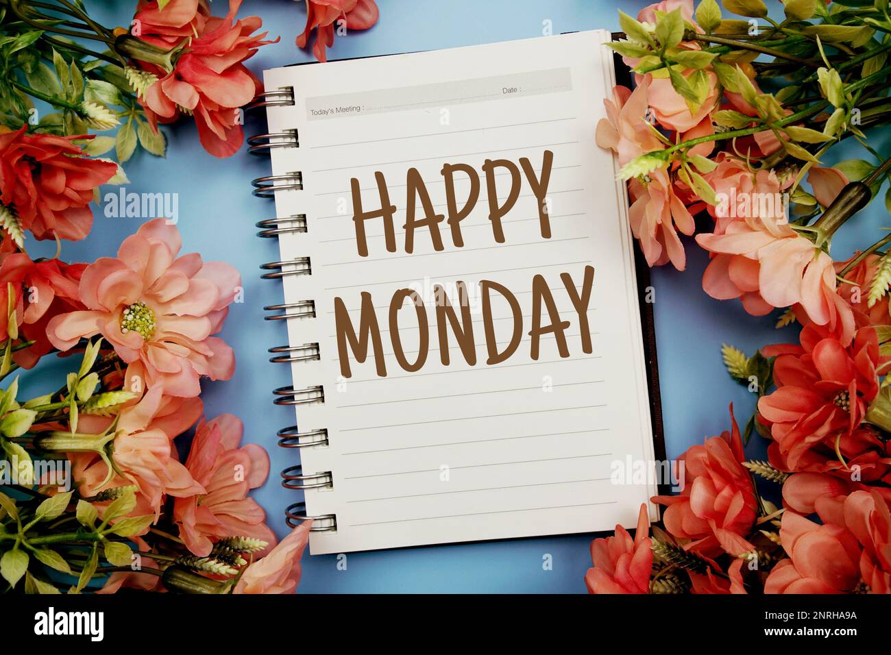 Happy Monday Typografie Text auf Papier Notizbuch flach auf blauem Hintergrund Stockfoto
