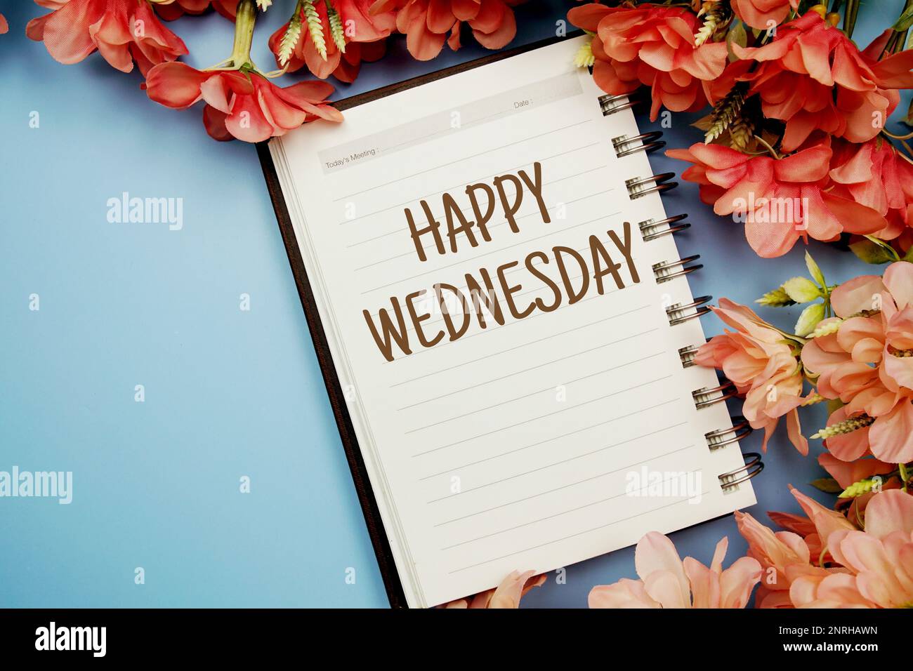 Happy Wednesday Typografie Text auf Papier Notizbuch flach auf blauem Hintergrund Stockfoto