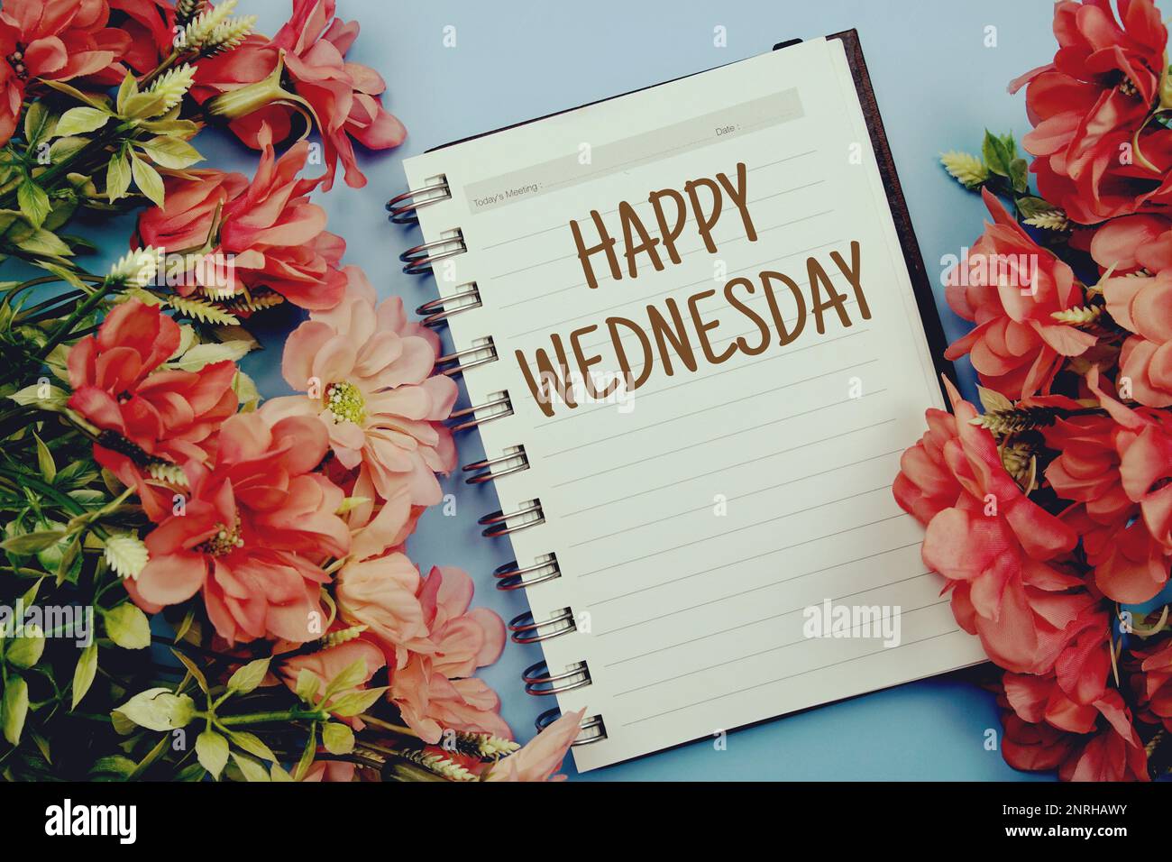 Happy Wednesday Typografie Text auf Papier Notizbuch flach auf blauem Hintergrund Stockfoto