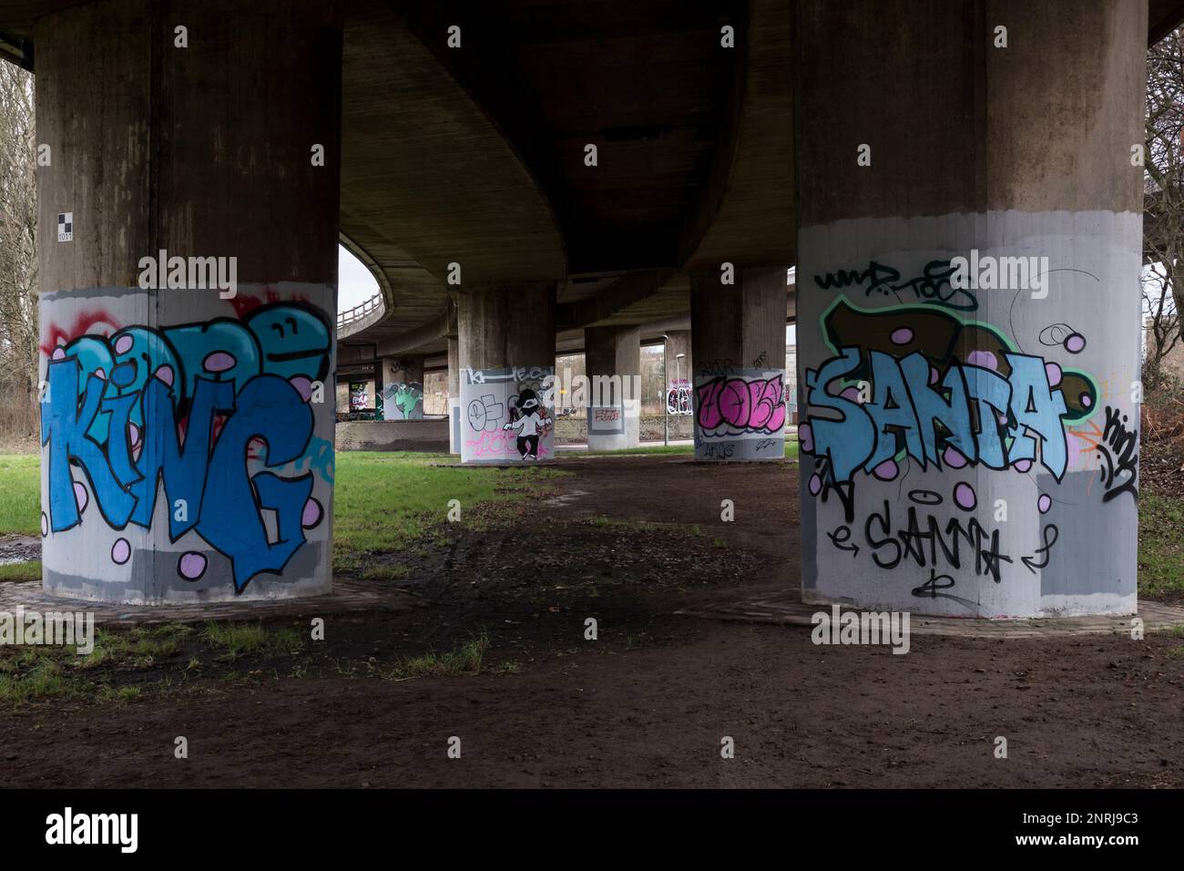 Graffiti auf den Betonstützen unterhalb einer Autobahnüberführung, Glasgow, Schottland, Großbritannien, Europa Stockfoto