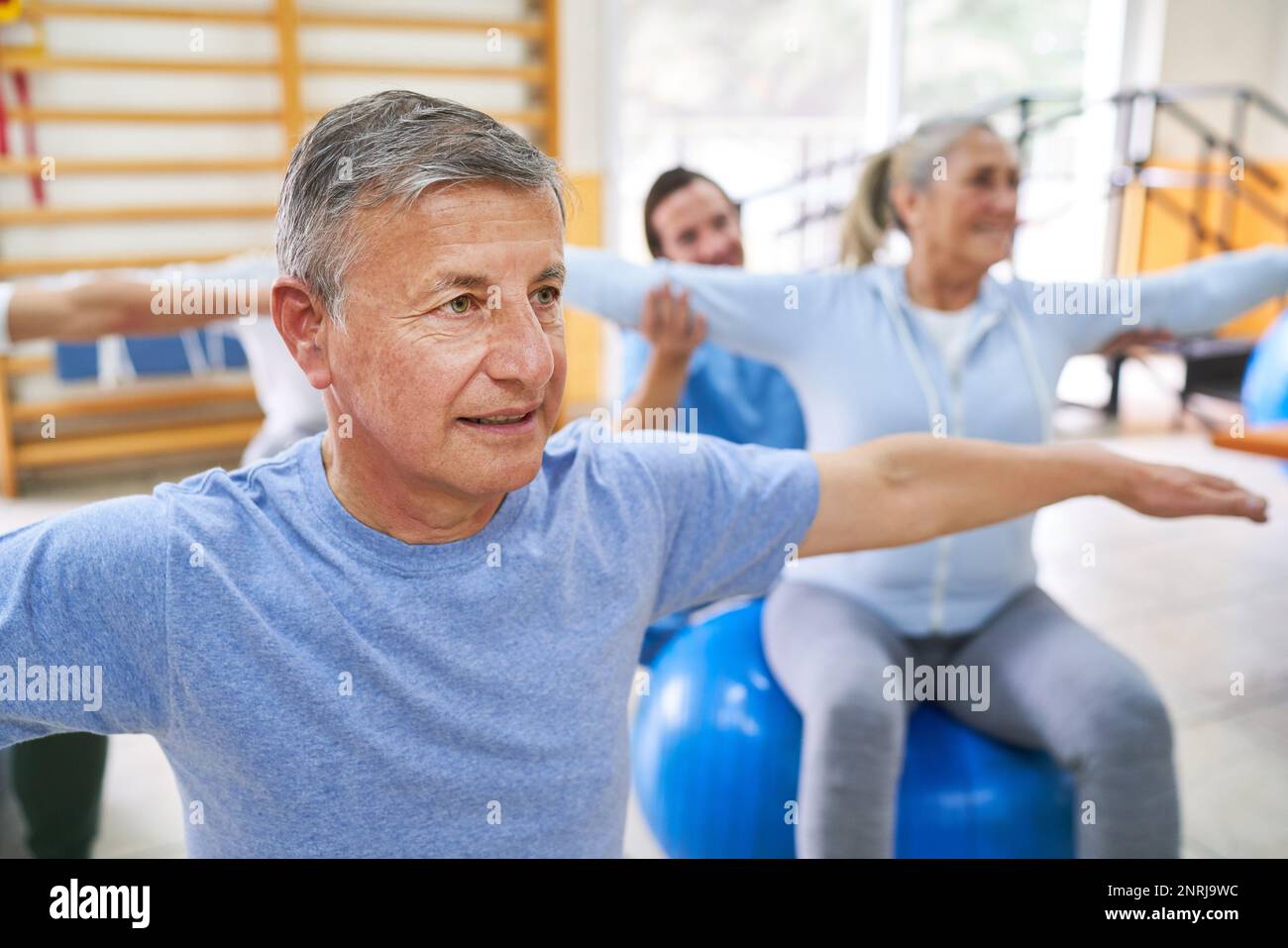 Ältere Männer und Frauen beim Fitnesstraining während des Trainingskurses im Rehabilitationszentrum Stockfoto
