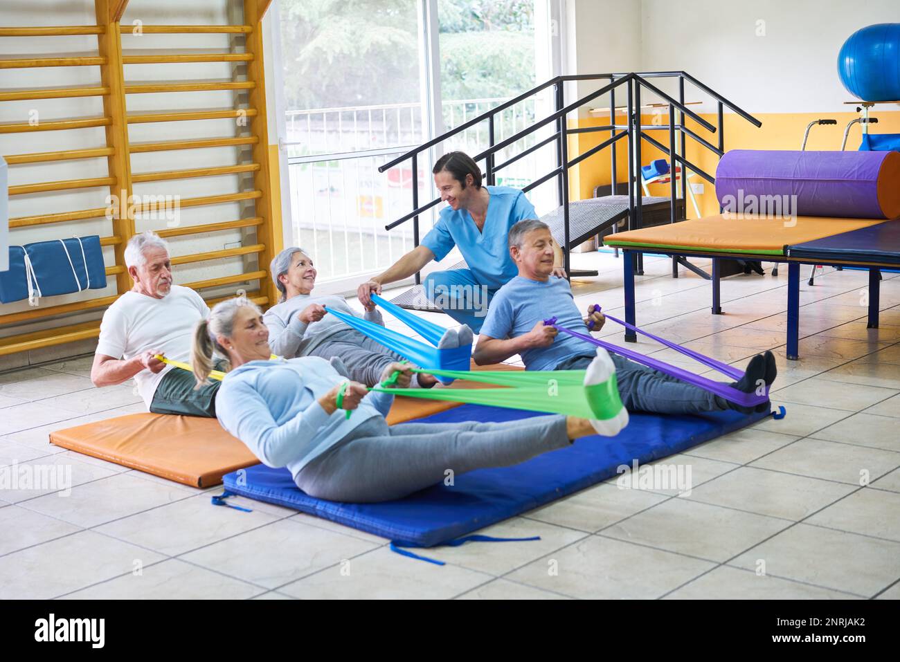 Gruppe älterer Menschen, die mit einem Trainer im Rehabilitationszentrum im Fitness-Kurs trainieren Stockfoto