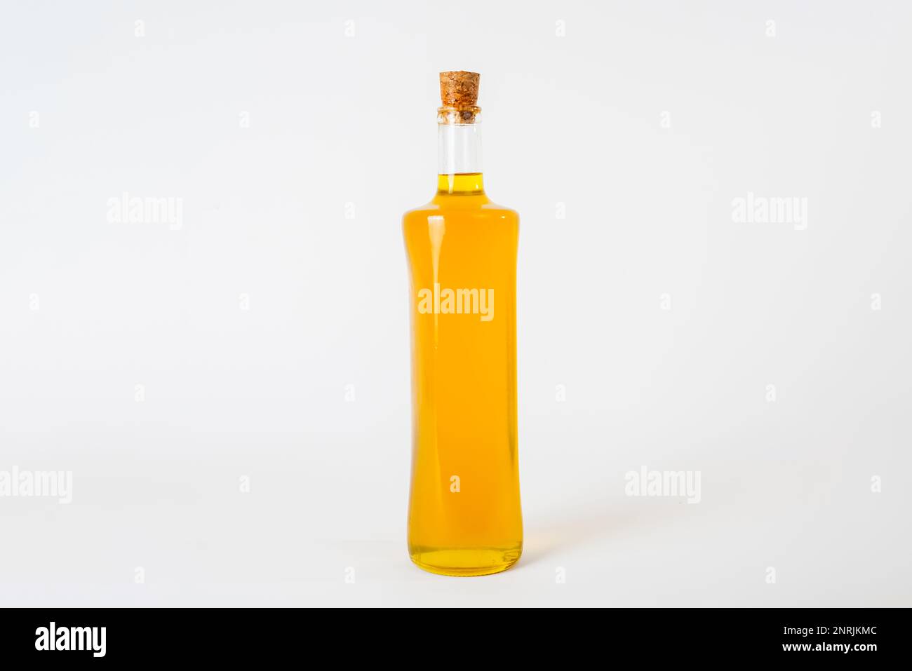 Olivenöl in einer Glasflasche mit einem Korkstopfen auf weißem Hintergrund. Stockfoto