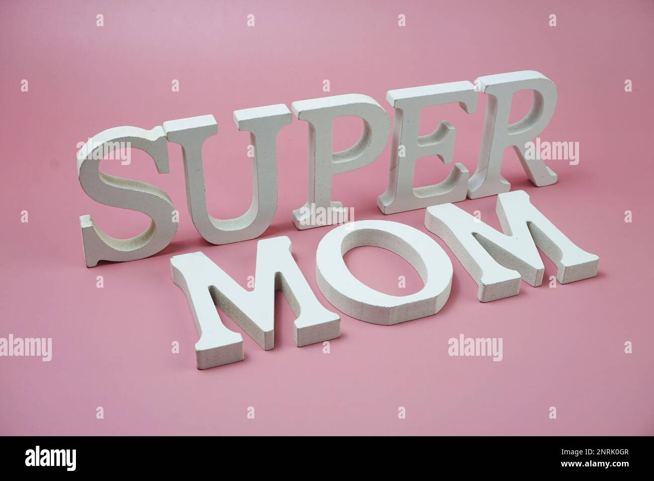 Buchstaben des Super-Mom-Wortes auf pinkfarbenem Hintergrund Stockfoto