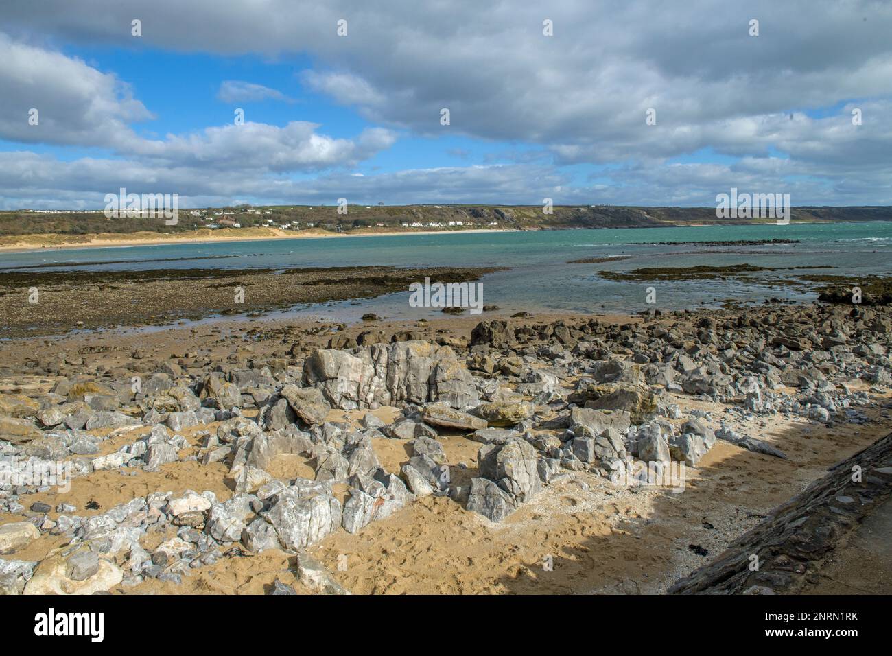 Blick über die Felsen von Port Eynon Beach in Richtung Horton Beach und die Klippen auf der Halbinsel Gower Stockfoto