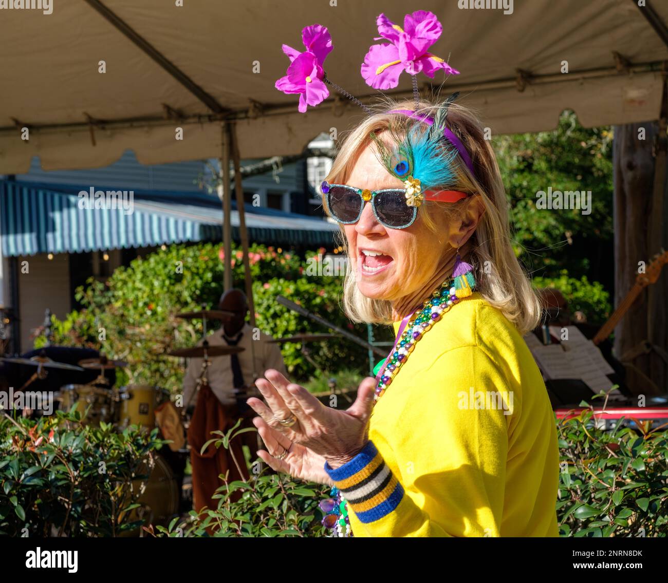 NEW ORLEANS, LA, USA - 18. FEBRUAR 2023: Farbenfrohe Kostümbildnerin, die auf einer Mardi Gras Block Party im Viertel Uptown eine Rede hält Stockfoto