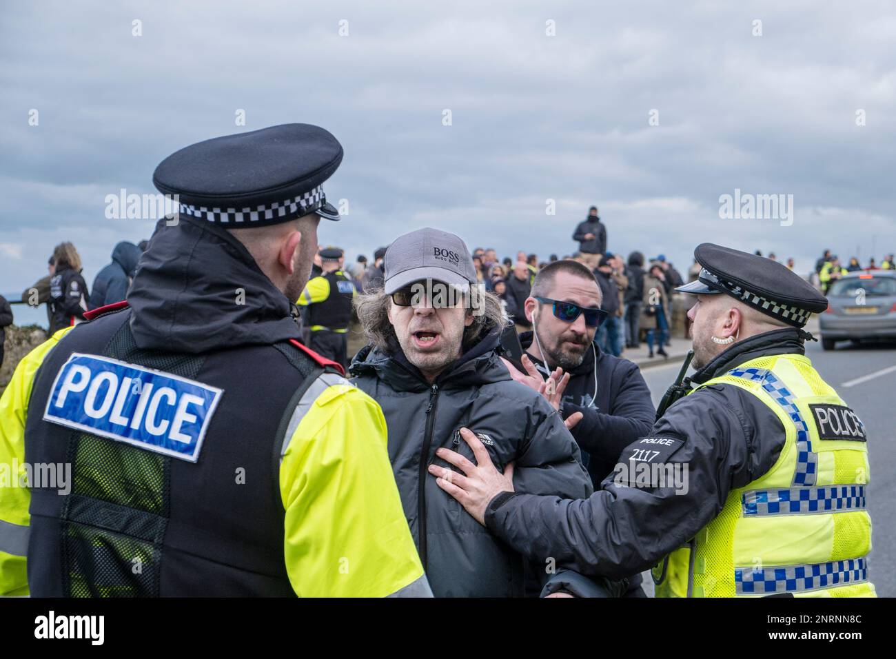 Devon und Cornwall Polizisten, die mit einem wütenden und frustrierten Demonstranten zu tun haben, der gegen Asylbewerber protestiert, die im Beresford H untergebracht sind Stockfoto