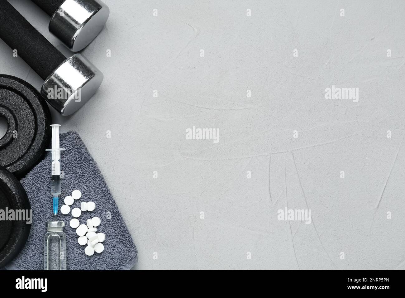 Verschiedene Drogen und Sportgeräte auf grauem Hintergrund, flach liegend mit Platz für Text. Dopingkontrolle Stockfoto