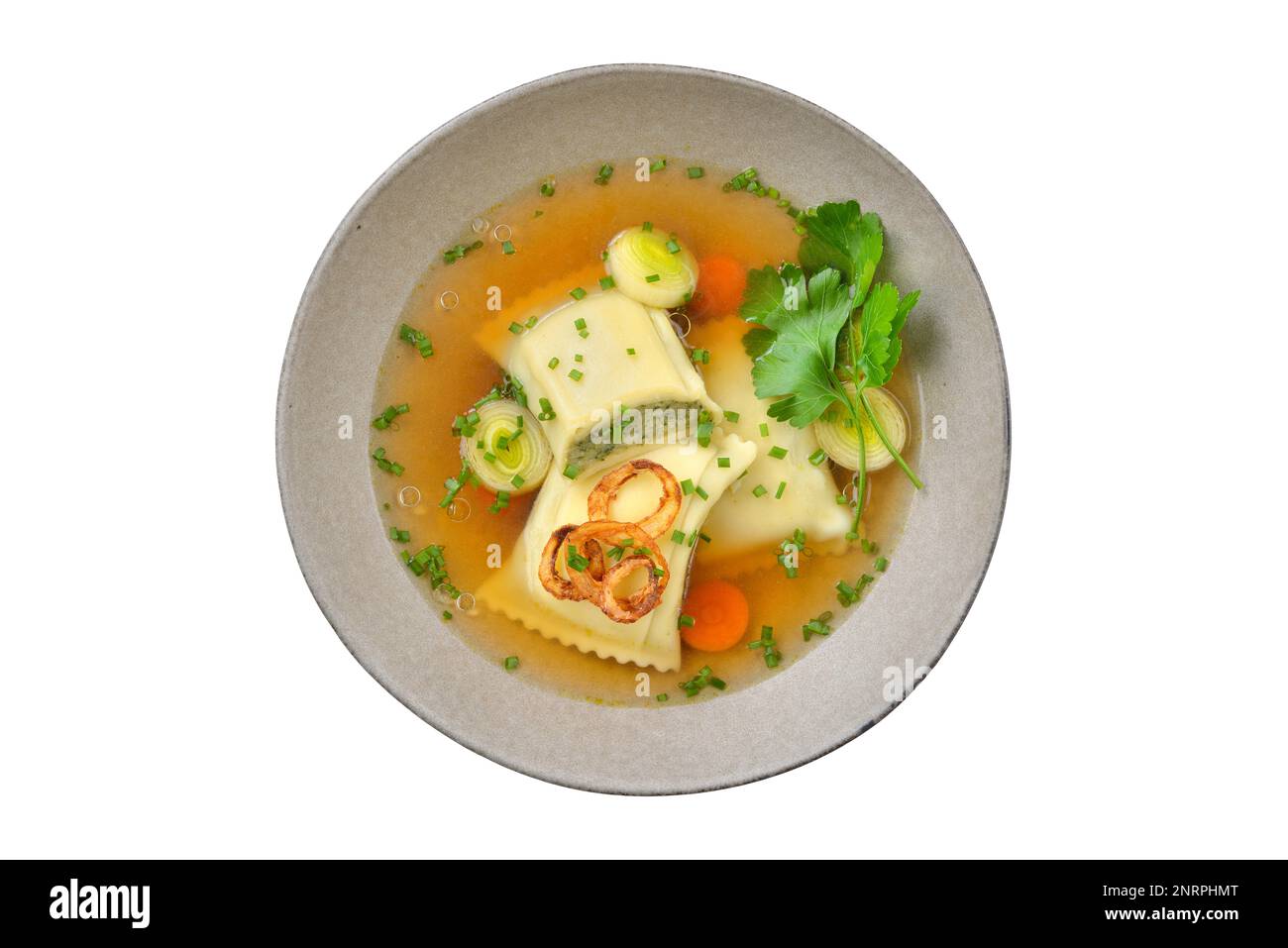 Köstliche Suppe mit schwäbischen Ravioli garniert mit gerösteten Zwiebelringen und serviert in einer grauen Keramikschüssel, isoliert auf weißem Hintergrund Stockfoto