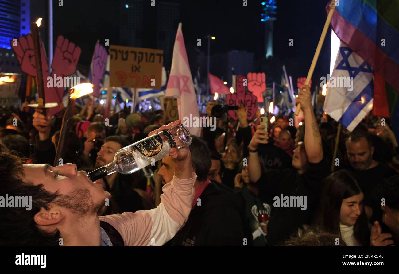 TEL AVIV, ISRAEL - FEBRUAR 25: Ein Protestteilnehmer trinkt Arak alkoholisches Getränk während einer Demonstration gegen die neue rechtsgerichtete Koalition des israelischen Ministerpräsidenten Benjamin Netanjahu und ihre vorgeschlagenen gerichtlichen Änderungen, die darauf abzielen, den Obersten Gerichtshof des Landes am 25. Februar 2023 in Tel Aviv, Israel, zu schwächen. Zehntausende Kundgebungen für die achte Woche in Folge in Israel gegen die weitreichende und umstrittene Reform des israelischen Rechtssystems. Stockfoto