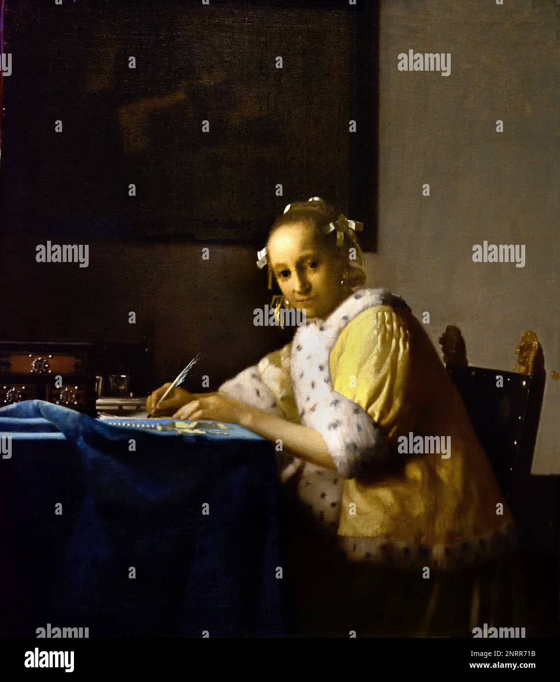 A Lady writing 1664-1667 von Johannes Vermeer oder Jan Vermeer 1632 - 1675, Delft, Niederlande, Holländisch, Holland, (Holländischer Maler im Goldenen Zeitalter, einer der größten Maler des 17. Jahrhunderts. Bevorzugte zeitlose, gedämpfte Momente, bleibt rätselhaft, unnachahmliches Farbschema und verwirrender Lichtinhalt) Stockfoto