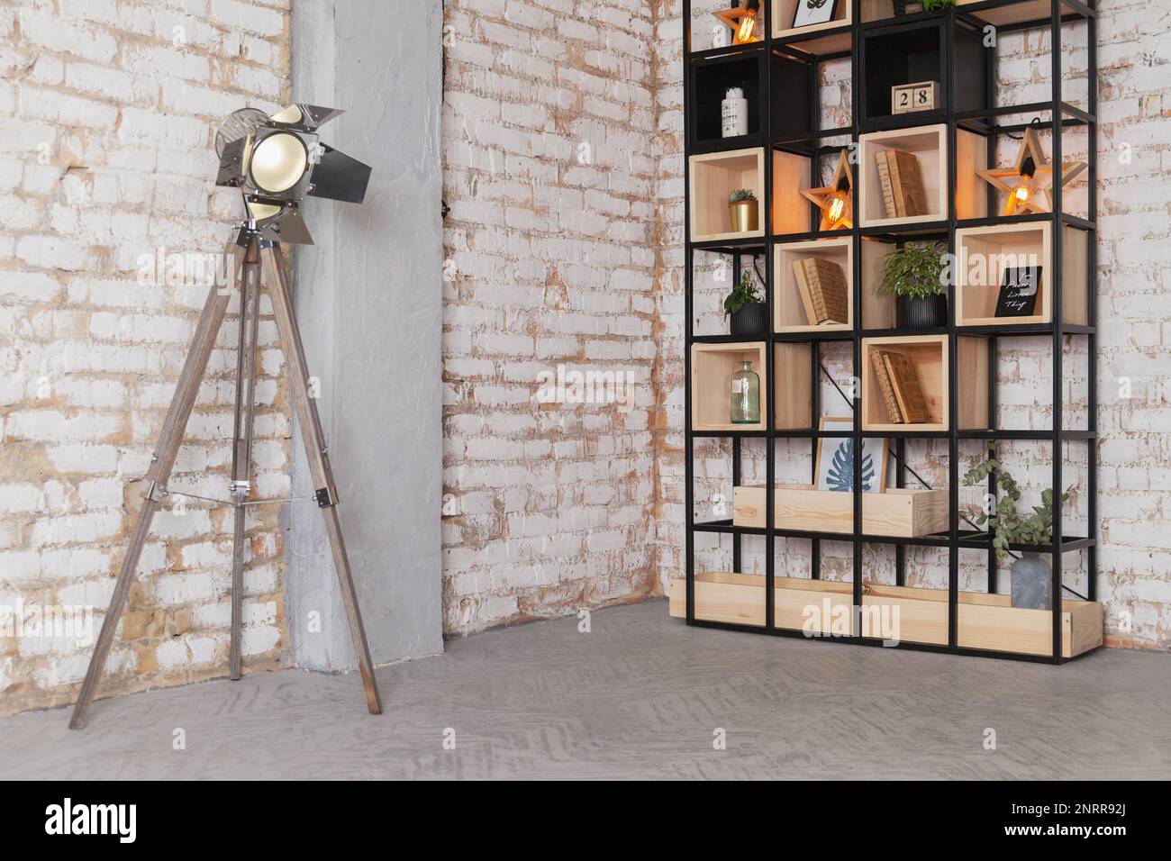 Loft modernes Wohnzimmer mit Fotostudio, Quelllampe, Bücherregal hinter einer natürlichen Backsteinwand. Kunstwerke, Business-Space-Konzept. Also Stockfoto