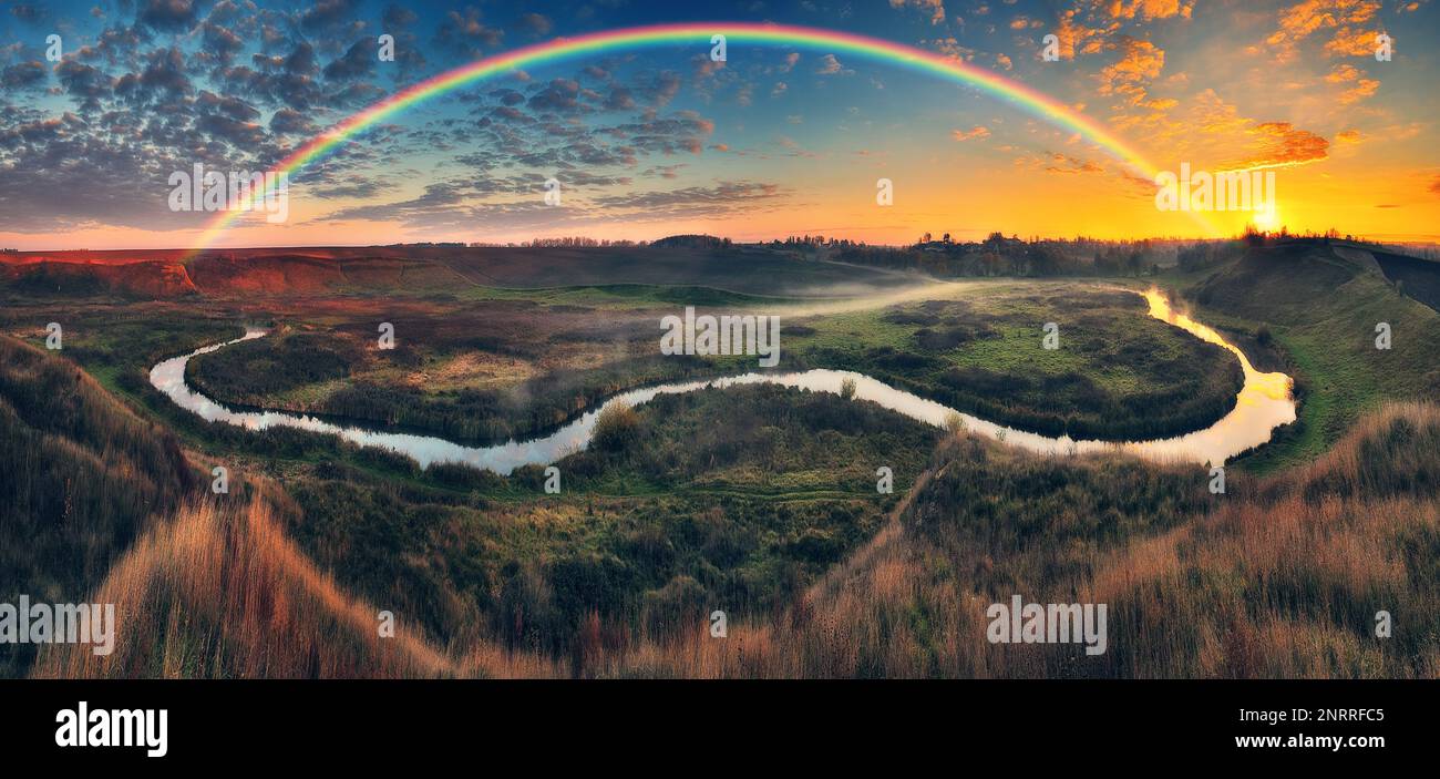 Fantastischer Regenbogen über dem kleinen ländlichen Fluss. Herbstmorgen. Art der Ukraine Stockfoto