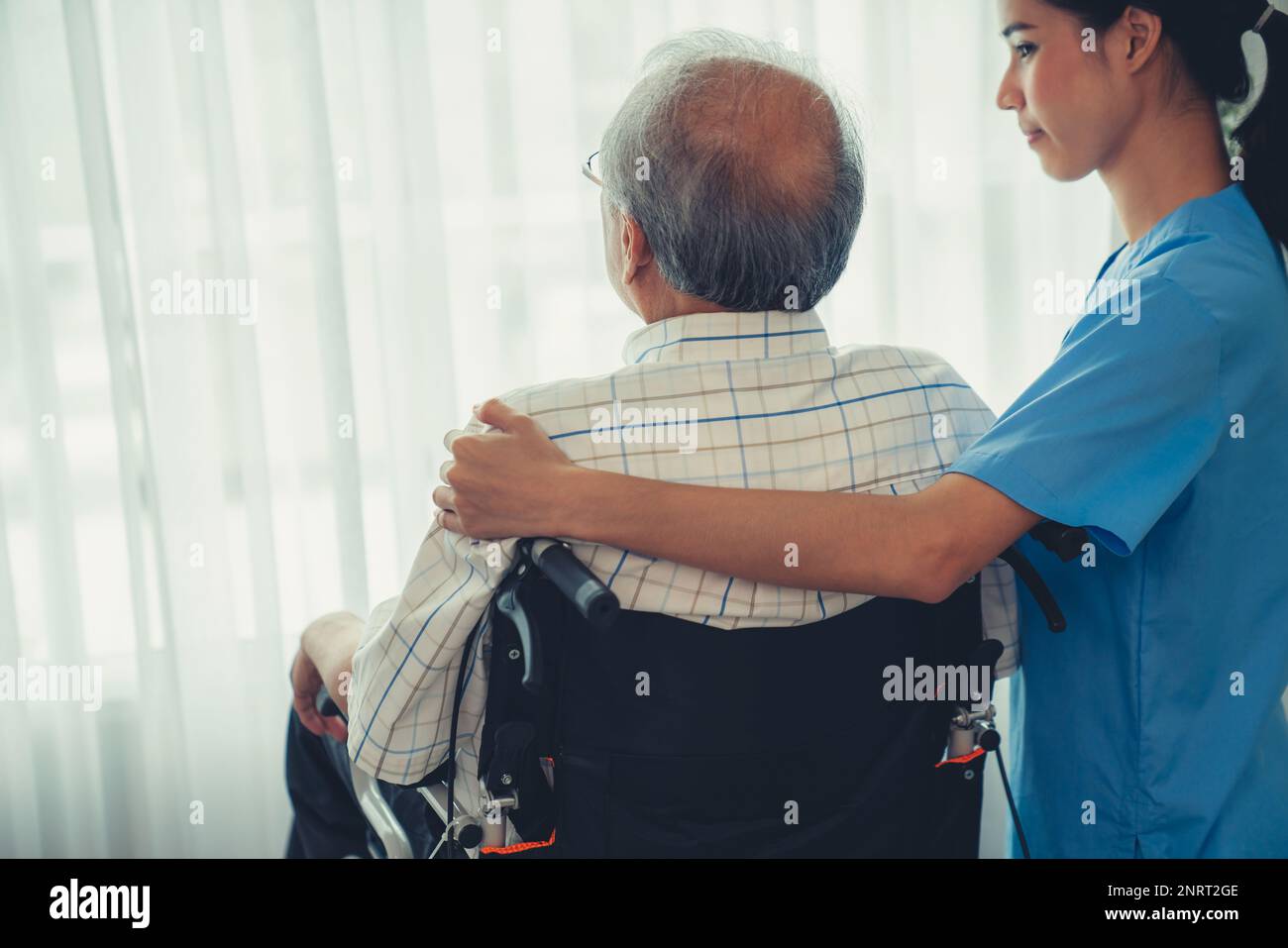 Rückansicht einer Pflegekraft und ihrer zufriedenen älteren Patientin