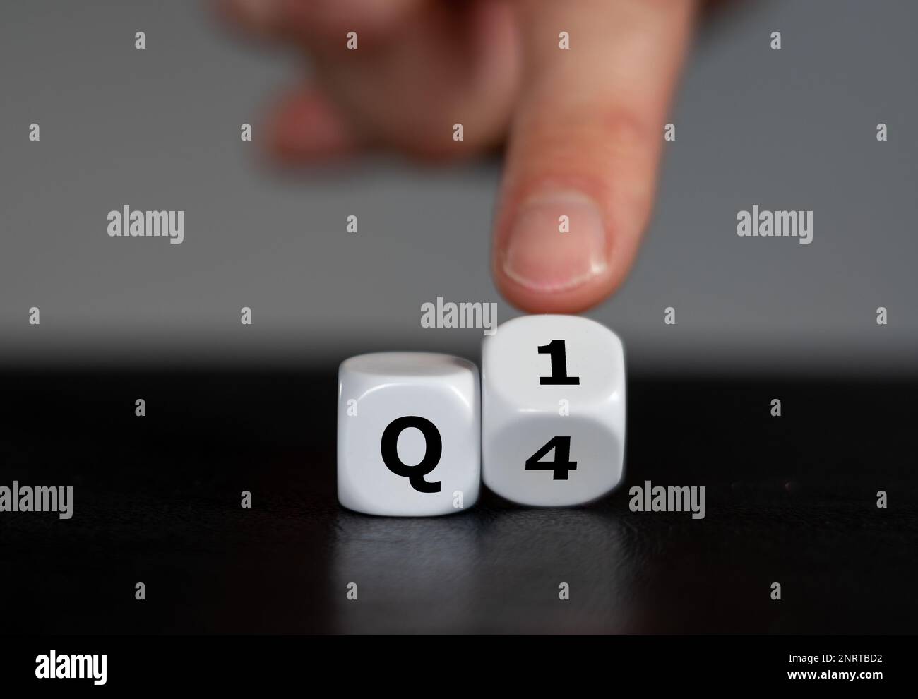 Symbol für das 1. Quartal des Jahres. Die Hand dreht Würfel und ändert den Ausdruck Q4 in Q1. Stockfoto