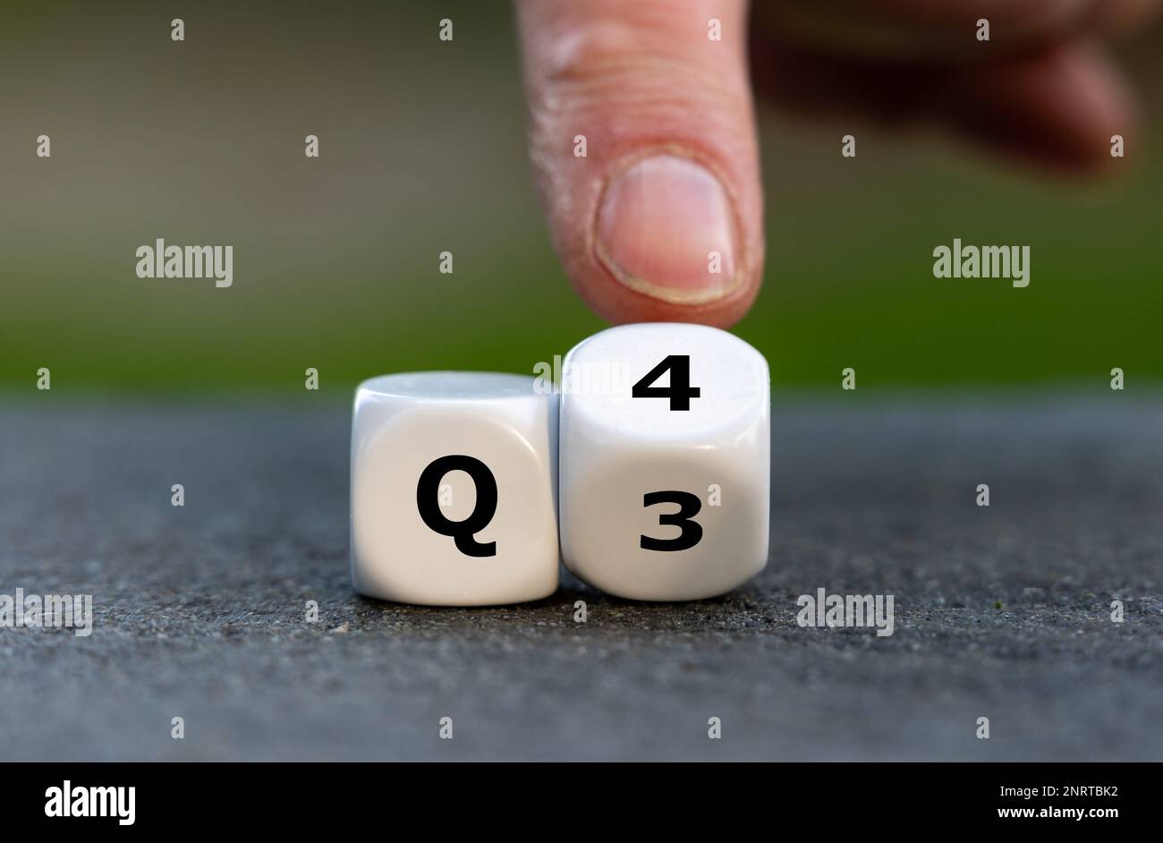 Symbol für das 4. Quartal des Jahres. Die Hand dreht Würfel und ändert den Ausdruck Q3 in Q4. Stockfoto