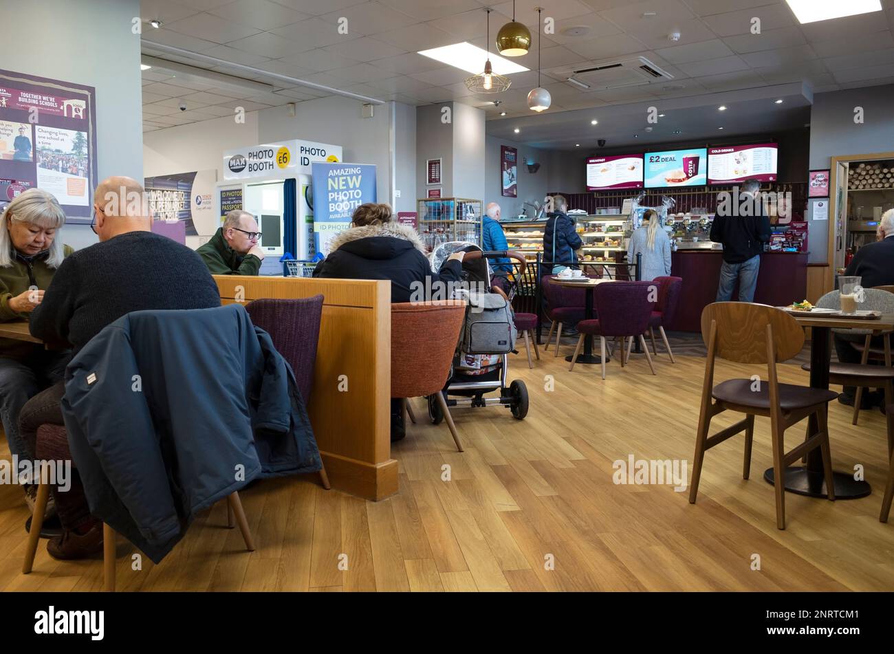 Leute, die in einer Filiale von Costa Kaffee trinken, gehört Whitbread in einem Tesco Supermarkt Stockfoto