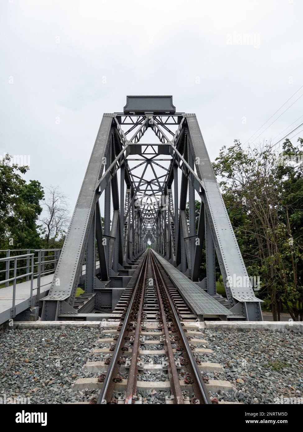 Die perspektivische Sicht auf die Stahlbrücke überquert den großen Fluss in der nördlichen Linie Thailands, Vorderansicht mit Kopierraum. Stockfoto