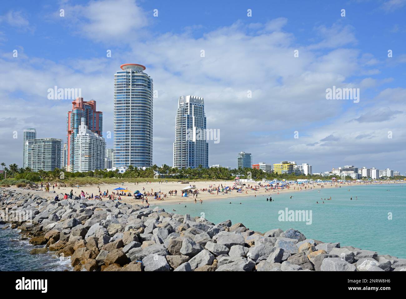 Blick auf Wolkenkratzer, South Pointe Park Pier und South Beach mit Sonnenanbetern, die Sonne, Strand und Atlantik genießen. Miami, Florida Stockfoto