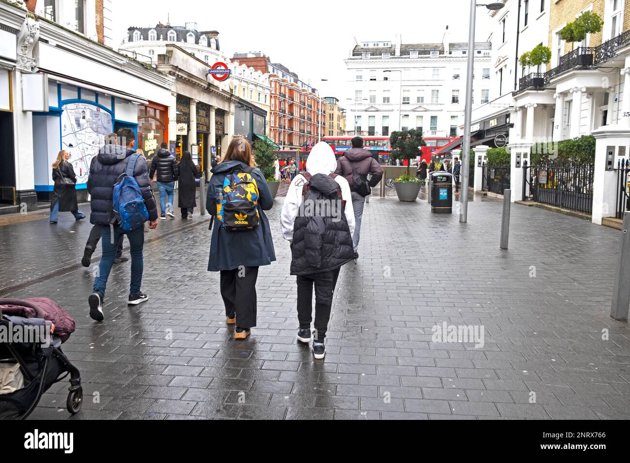 Rückansicht von Mutter und Sohn im Teenageralter 13 Besucher, die während der Schulferien in der Londoner Straße am 2023. Februar in Großbritannien KATHY DEWITT spazieren Stockfoto