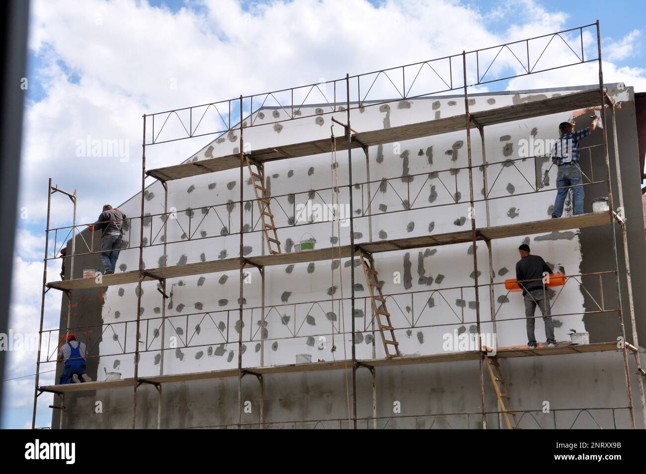 Isolierung des Hauses mit Polyfoam. Der Arbeiter installiert eine  Styroporplatte an der Fassade Stockfotografie - Alamy