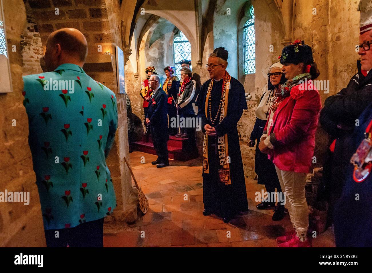 Der falsche Priester, die Nonne und andere Gäste sahen, wie das Paar die Kapelle betrat. Die Tradition der falschen Bauernhochzeit während des Karnevals reicht bis ins 16. Jahrhundert zurück, der Adel spielte die Rolle der Bauern und die Bauern waren die Lords. In Nijmegen waren Anja und Theo Wijlemans dieses Jahr das Hochzeitspaar des Bauern. Das Paar versammelte sich in der Valkhof-Kapelle, trug traditionelle Bauernkleidung und war umgeben von Menschen in lebhaften Kostümen. Die Hochzeit des Bauern ist eine der niederländischen Karnevalstraditionen, insbesondere in Limburg, Nordbrabant und Gelderland. Die Umkehrung Stockfoto