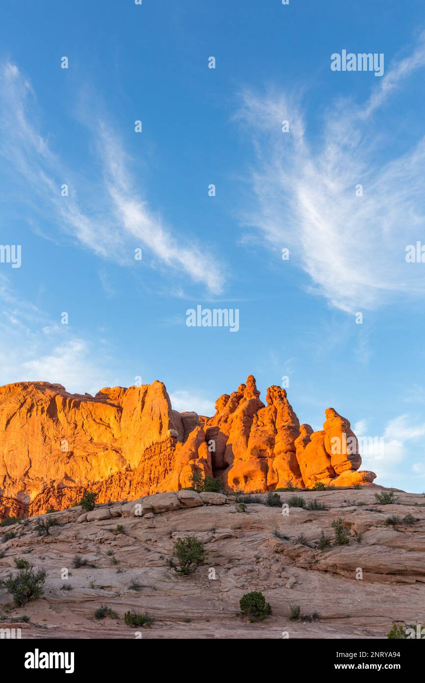 Zirrus Wolken über den Entrada Sandsteinformationen der Navajo Felsen bei Sonnenuntergang in der Nähe von Moab, Utah. Stockfoto
