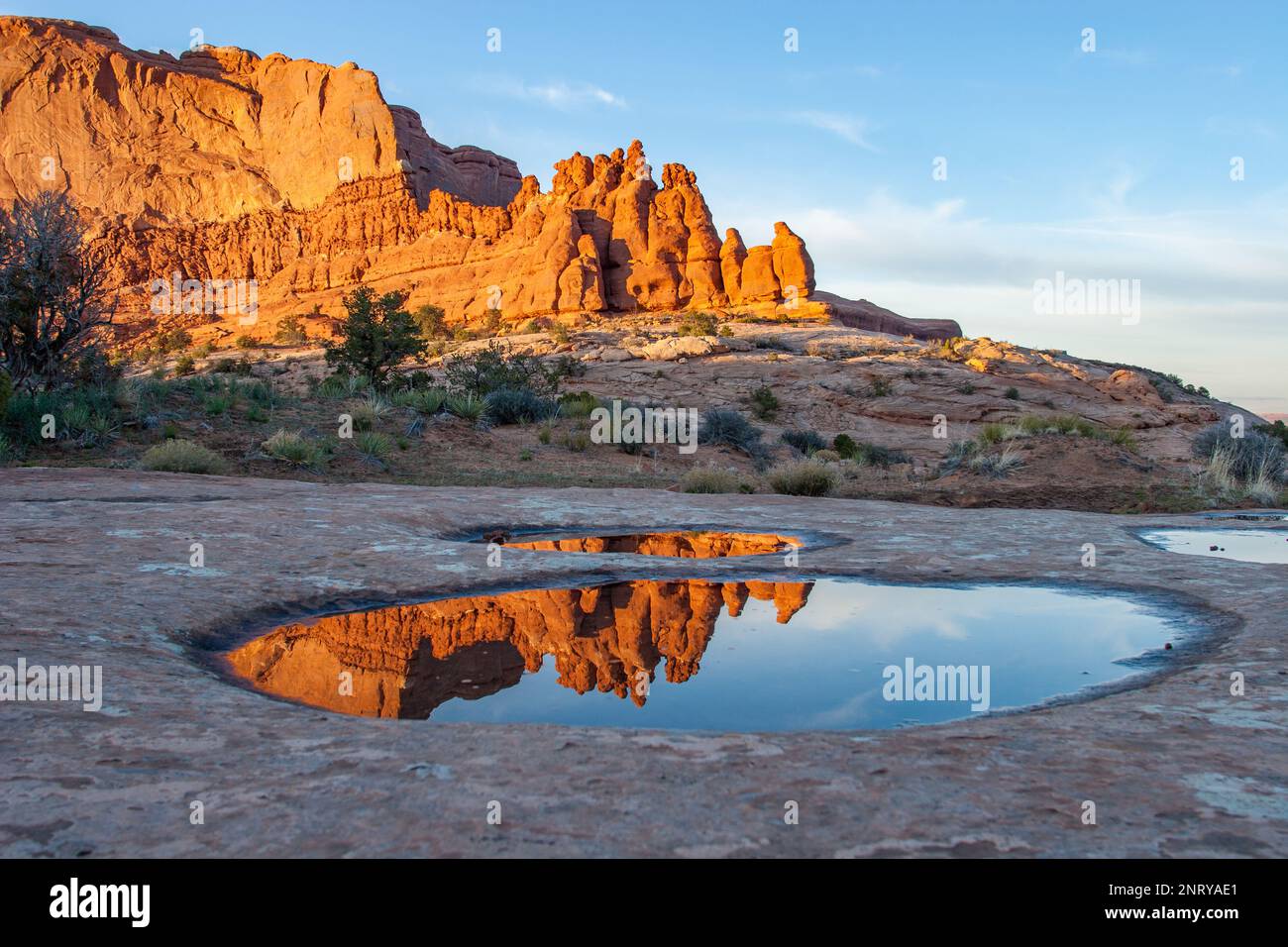 Die Entrada-Sandsteinformationen der Navajo-Felsen spiegeln sich in einem temporären Pool in Navajo-Sandstein bei Moab, Utah, wider. Stockfoto