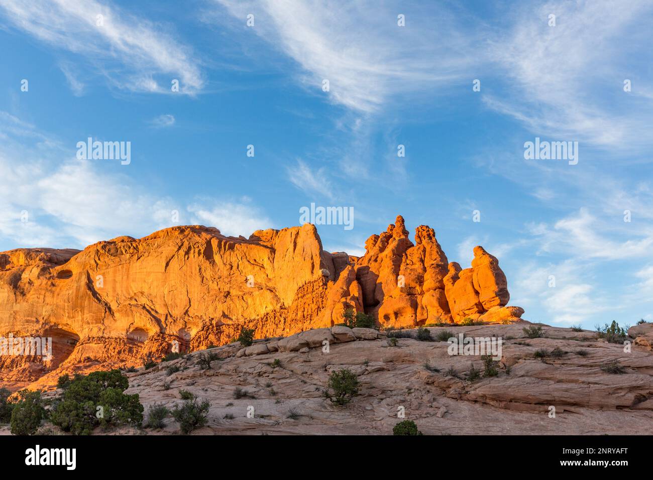Zirrus Wolken über den Entrada Sandsteinformationen der Navajo Felsen bei Sonnenuntergang in der Nähe von Moab, Utah. Stockfoto