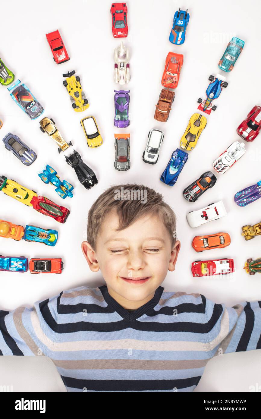 Porträt eines kaukasischen Kindes mit Spielzeugautos auf Weiß Stockfoto