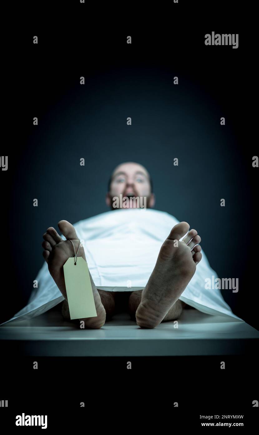 Ein toter Mann wacht auf dem Leichenschautisch auf Stockfoto