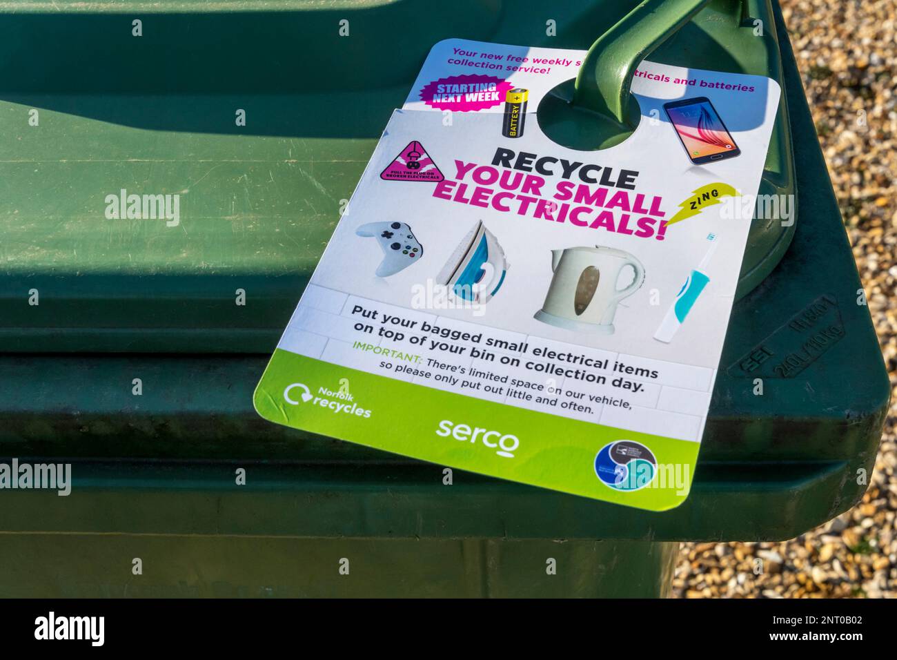 Ein Hinweis, der einem Recyclingbehälter beigefügt ist, fordert die Mitarbeiter auf, kleine elektrische Geräte zu recyceln. Stockfoto