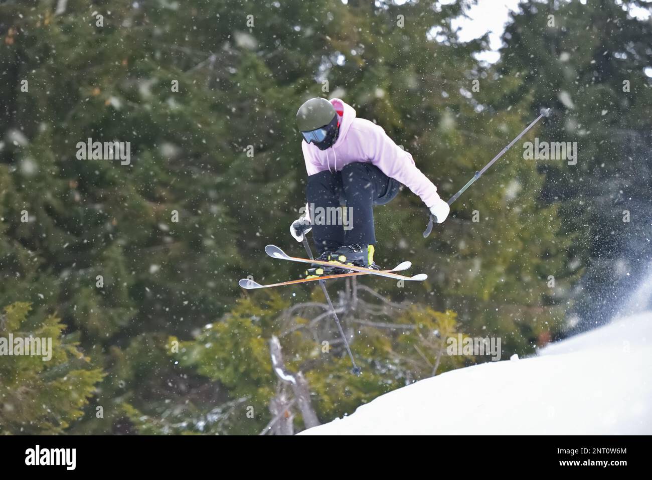 Extreme Wintersportarten: Skifahrer nehmen die Schwerkraft mit Freestyle-Skills auf. Der Skifahrer kann mit Leichtigkeit einen perfekten Sprung ausführen Stockfoto