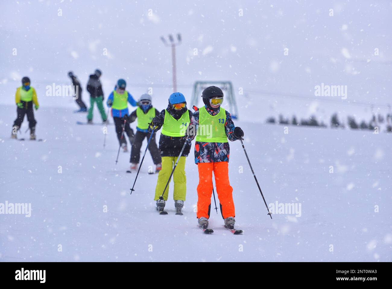 Schneetag in der Skischule: Kinder haben Spaß im Schnee, während sie neue Fähigkeiten erlernen Stockfoto